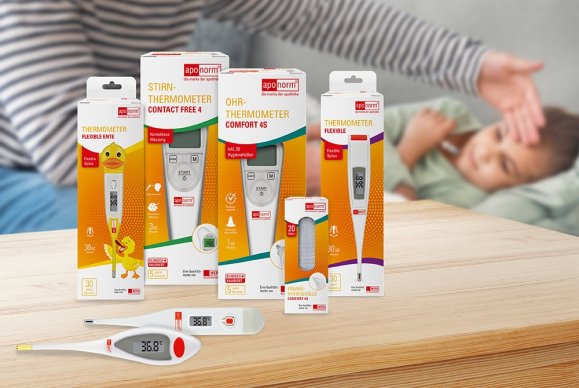 Fieberthermometer Im Hintergrund liegt ein krankes Kind im Bett, mit einer Hand am Kopf. Im Vordergrund sind verschiedene Produkte von Aponorm, darunter Thermometer, zu sehen.