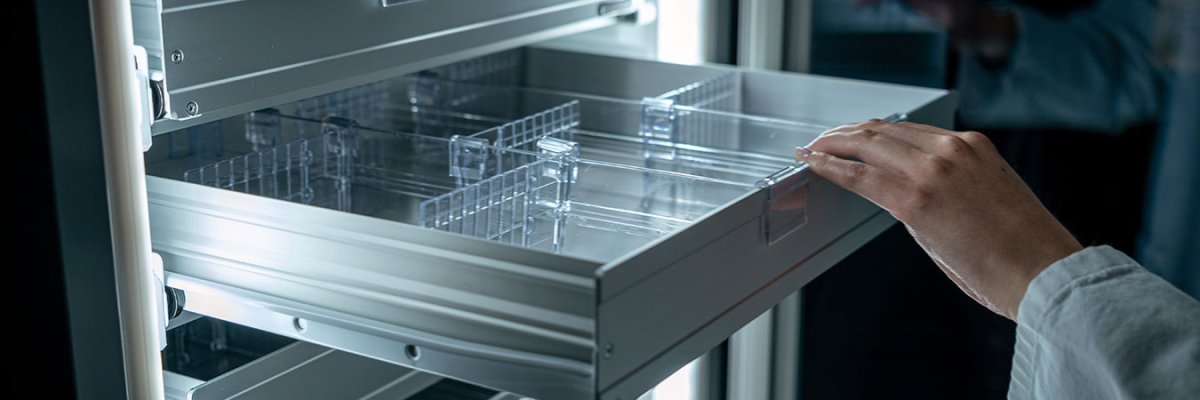 Hand zieht Kühlschrankfach auf