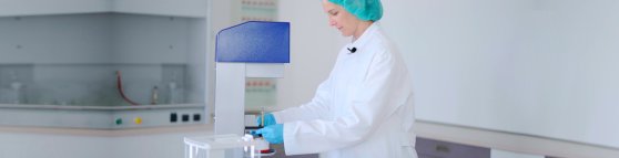 Topitec Header 3 Eine Apothekerin in blauen Handschuhen zeigt, wie man den Topitec benutzt.