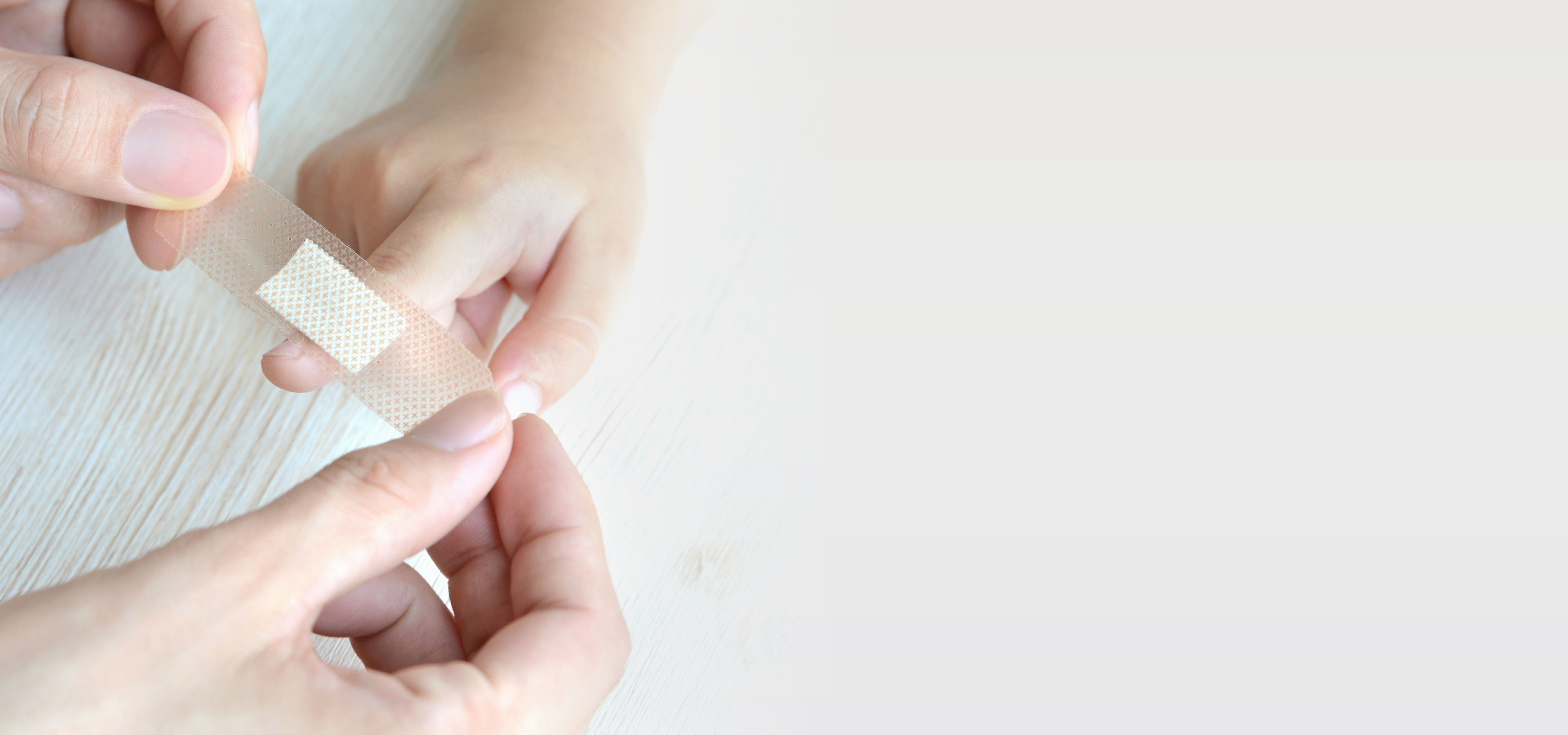 WEPA-Pflaster Eine Person klebt sich ein Pflaster auf einen Finger
