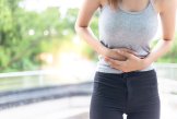 Wärmepflaster Bauch Eine Frau hält sich den Bauch vor schmerzen zu