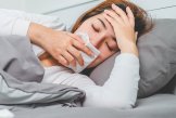 Krank im Bett Eine Frau liegt krank im Bett